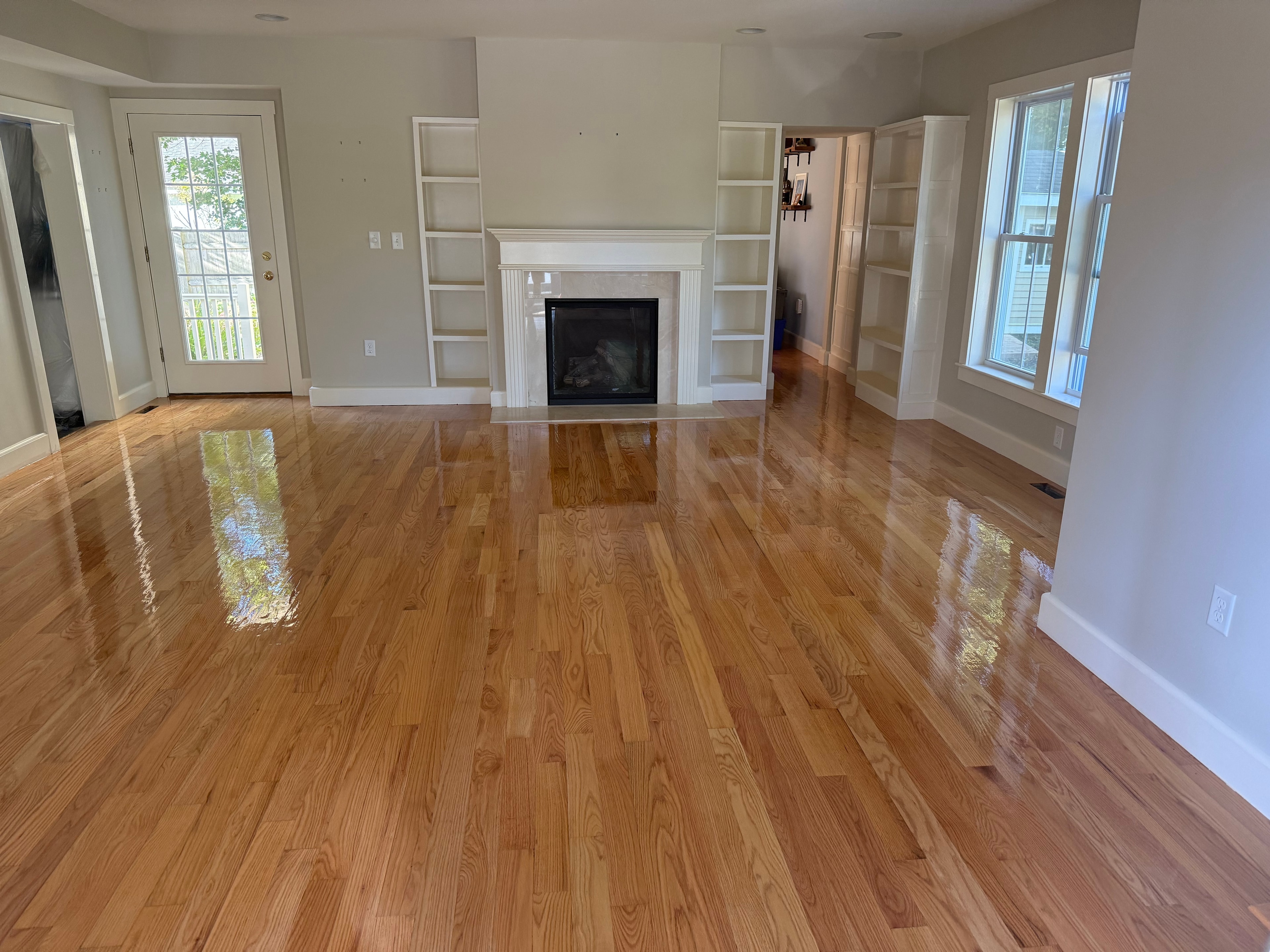 Gleaming refinished hardwood floors in living room with fireplace