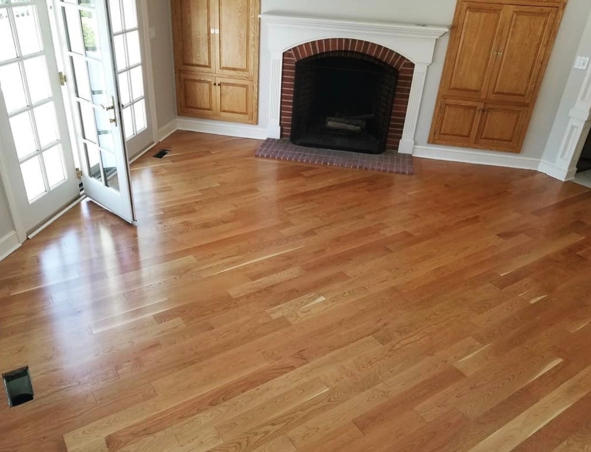 Refinished hardwood floors with brick fireplace and built-in cabinetry