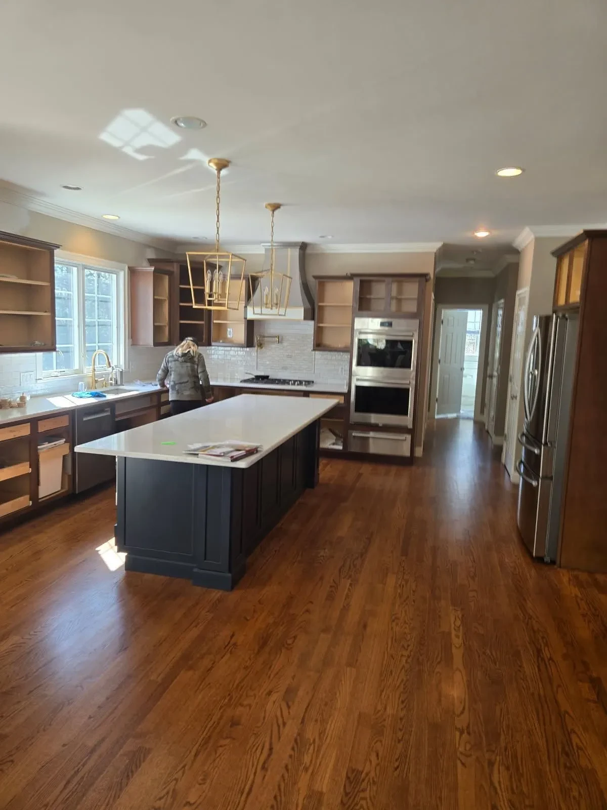 Dark stained hardwood floors in kitchen with large island